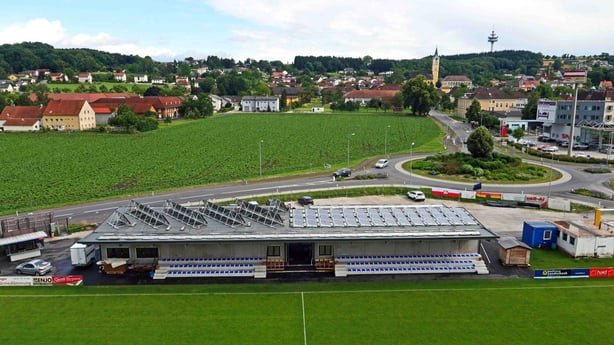 Luftaufnahme der Sonnenarena der Union Ansfelden. Das vollsolar beheizte Vereinsheim mit großer Photovoltaik-Anlage auf dem Dach liegt direkt am Fußballplatz.